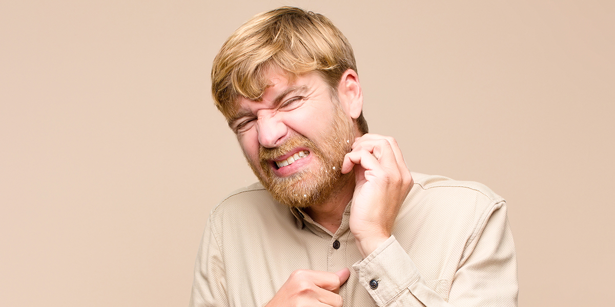 A man scratching his itchy beard
