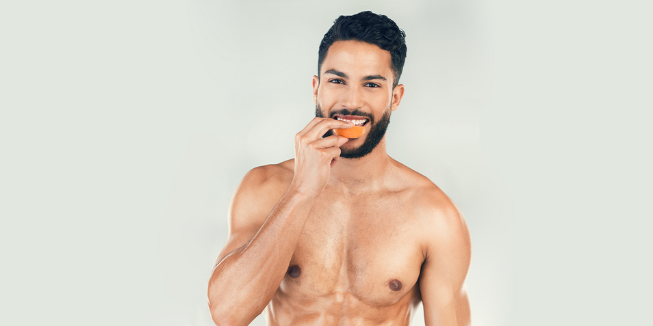 A bearded guy eating a fruit